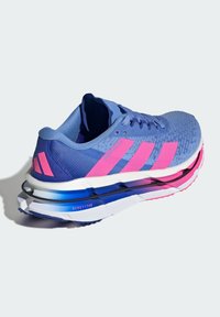 Atletiekschoen met een blauwe mesh upper en roze accenten, voorzien van een dikke witte tussenzool met een gelaagd ontwerp en zichtbare demping.