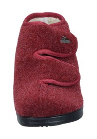 Red fuzzy slipper with a rounded toe, soft texture, contrasting black sole, and two decorative loops on the front. FLY FLOT logo on the side.