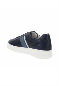 Zapatilla de piel azul marino con acabado suave, suela de goma blanca y acentos de rayas verticales azules en el lateral. Cierre de cordones clásico.