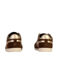 Zapatillas de ante marrón con acentos metálicos dorados, suela de goma blanca y un diseño trasero liso y curvado.