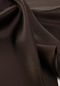 Tessuto satin marrone scuro con una superficie liscia e lucida, piegato per mostrare la sua finitura morbida e il sottile lucido. Il bordo è cucito in modo pulito.