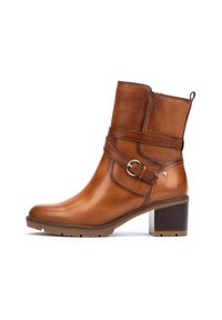 Bottine en cuir marron, avec un bout carré, fermeture éclair latérale et détail de boucle. Présente un talon en bois et une semelle extérieure en caoutchouc texturé.