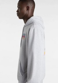 Grijze hoodie van katoenmix. Voorzien van een kangoeroezak, verstelbare trekkoorden in de capuchon en kleurrijke opdruk op de borst en mouwen.