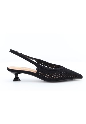 Scarpa slingback nera con punta a punta, tomaia traforata e tacco basso dalla forma unica su sfondo bianco.