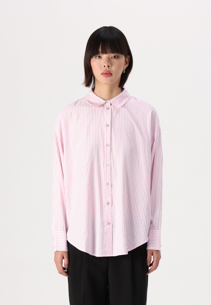 Camicia a maniche lunghe con bottoni di colore rosa chiaro a strisce verticali bianche. Presenta un colletto a punta e maniche con polsini. Tessuto dalla trama liscia.