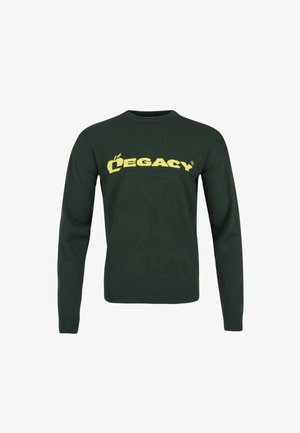 Sweater verde escuro com decote redondo e mangas longas, apresentando letras em amarelo em destaque "LEGACY" na parte frontal. Textura de malha simples.