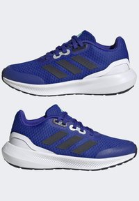 Scarpe da ginnastica blu con tomaia in mesh, tre strisce nere sui lati, suola bianca e dettaglio testurizzato sul tallone. Lacci dello stesso colore.