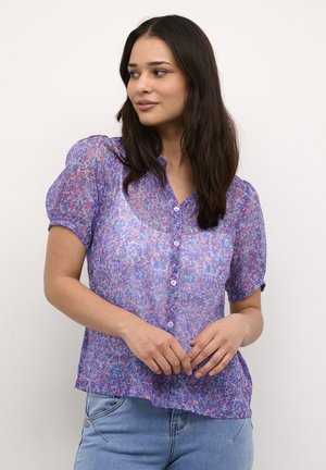 Durchsichtige lila Bluse mit floralem Muster, kurzen Puffärmeln und Knopfleiste. Leichter Stoff mit einem leicht lockeren Schnitt.