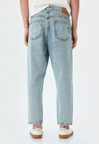 Jeans in denim azzurro chiaro con una vestibilità comoda, dotati di una vita alta, due tasche posteriori e un'etichetta in pelle sul retro.
