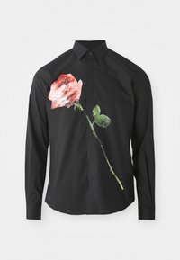 Zwarte lange mouw shirt met een grote rode rozenafbeelding aan de linkerkant met groene bladeren, gemaakt van een gladde stof.