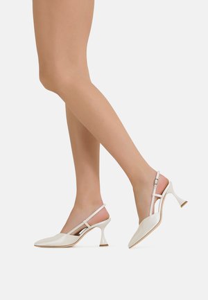 Tacchi slingback bianchi con punte appuntite, sottili cinturini alla caviglia e un design del tacco curvo unico. Realizzati in materiale di pelle lucida.
