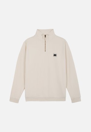 Pull beige à manches longues avec demi-fermeture éclair et petit écusson avec logo ours noir sur le côté gauche de la poitrine, poignets et ourlet côtelés.