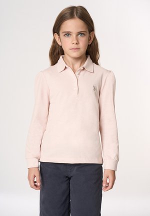 Polo a maniche lunghe di colore rosa pallido con colletto classico, abbottonatura e logo ricamato. Abbinato a pantaloni scuri, presenta una texture morbida.