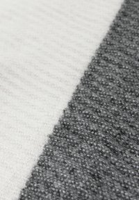 Textile featuring a split design: one side in smooth white with fine stripes, the other in textured dark gray with a mottled pattern.