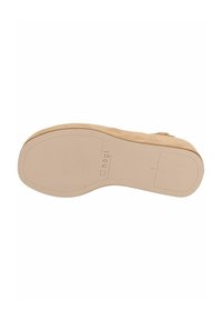 Beige podrážka boty s hladkým, plochým povrchem; má jemné branding a obrysy. Materiál vypadá měkce s minimálním vzorem podrážky.