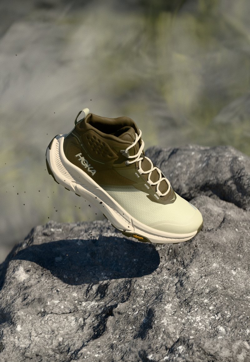 Vieglu skriešanas apavu krēmīgā un olīvzaļā krāsā ar teksturētu virsu, izturīgām šņorēm un Vibram zoli, kas nodrošina saķeri.