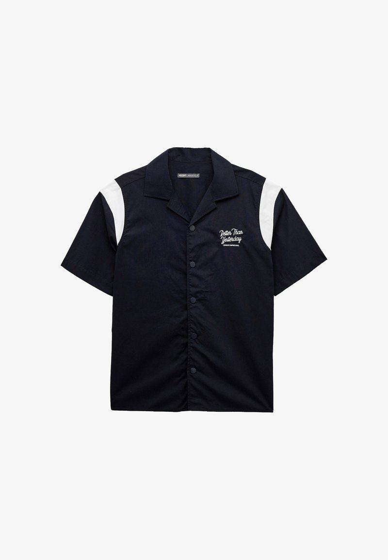 Czarna koszula z krótkim rękawem z białymi panelami akcentującymi. Posiada zapięcie na guziki z przodu oraz haftowany tekst na lewej piersi. Gładka faktura materiału.