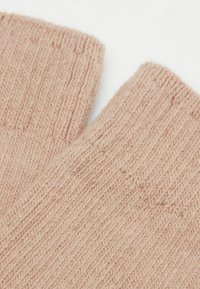 Dzianinowe rękawiczki bez palców w jasnym różu. Posiadają ribbed strukturę z drobnym plecionym wzorem, pokazując miękką włóczkę i przytulny design.