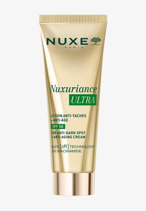 Tubo dorato di crema NUXE Paris Nuxuriance Ultra anti-macchie scure e anti-età con SPF 30 e 5% niacinamide, tecnologia ALFA [3R].