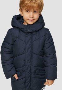 Dunkelblauer Steppmantel mit Kapuze, ausgestattet mit einem Reißverschluss vorne, Druckknöpfen und zwei Fronttaschen mit gesteppten Akzenten. Weicher, gestepptener Stoff.