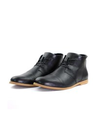 Botas de ante negras hasta el tobillo con punteras redondeadas, minimalismo en los cordones y un acabado liso. Presenta una suela de goma marrón claro para mayor tracción.