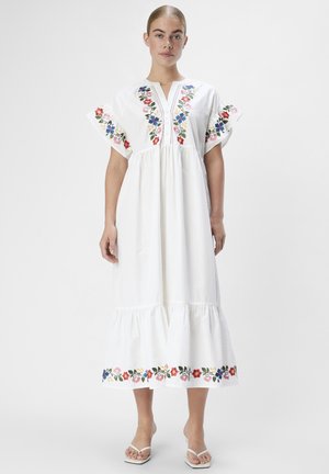 Abito in cotone bianco con ricami floreali sulle maniche e sull'orlo, fondo a strati, maniche corte a sbuffo e scollatura a V.