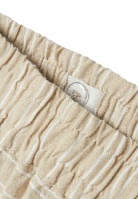 Hellbeige Stoff mit dezenten weißen Streifen, ergänzt durch geraffte elastische Details an der Taille und einem transparenten Knopfakzent.