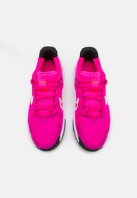Baskets de sport roses vives avec un tissu texturé, des accents blancs et une semelle noire. Les caractéristiques du design comprennent un col rembourré et des lacets.
