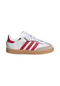 White sneaker with red stripes, suede toe cap, and gum rubber sole. Features a lace-up design and padded collar. "Samba" branding visible.
