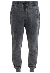 Mörkgrå acid-wash joggerbyxor med elastisk midja, svart dragsko, fickor med dragkedja på sidorna och muddar vid anklarna.