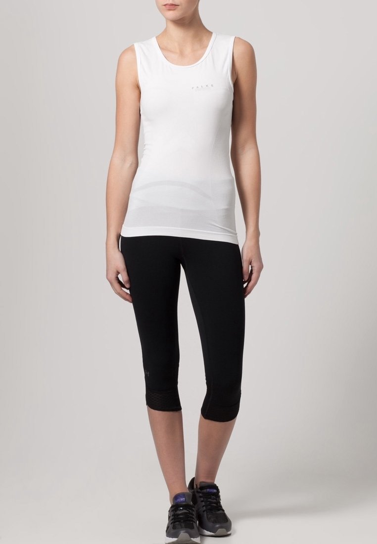 Top atletico senza maniche bianco con scollatura tonda, abbinato a leggings capri neri. Entrambi realizzati in tessuto elasticizzato e traspirante.