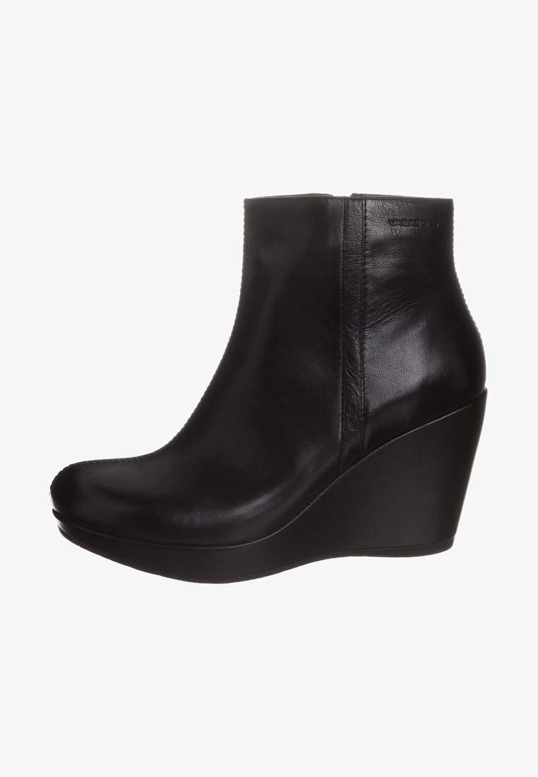 Černé kožené kotníkové boty s kulatou špičkou, vysokým klínovým podpatkem a hladkým povrchem. Charakterizují je minimální švy a elegantní silueta.