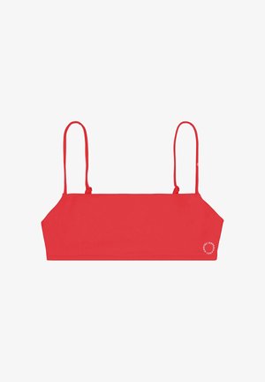 Piros, rövidített fazonú trikó vékony, állítható vállpántokkal és egy kis fehér kör alakú logóval az alsó jobb sarokban.