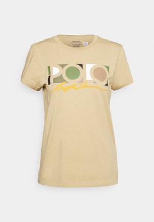 Beige cotton t-shirt with short sleeves; features "POLO" logo in green, cream, and brown rectangular sections; yellow embroidered text below.