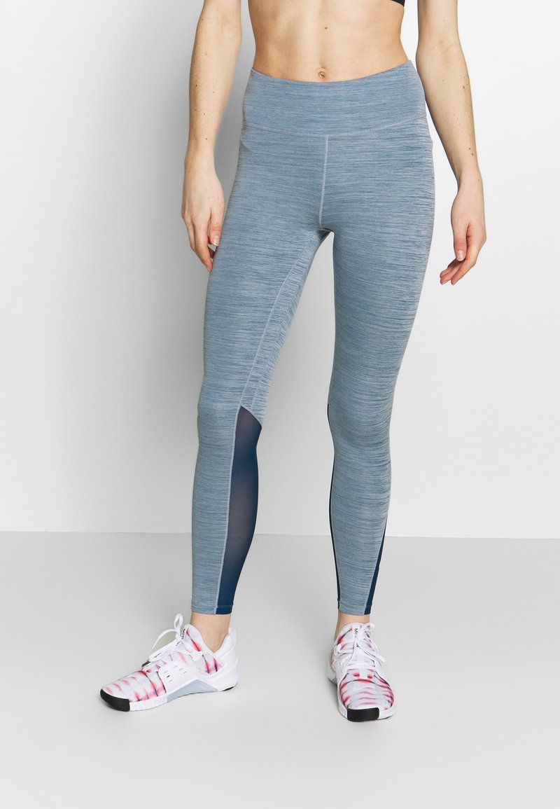 Světle modré sportovní legíny s texturovaným vzorem a tmavomodrými síťovinovými akcenty po stranách, s vysokým pasem.