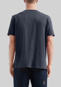 T-shirt pour homme à manches courtes en coton bleu marine, avec une coupe décontractée, une texture lisse et un ourlet droit avec une étiquette sur le côté.