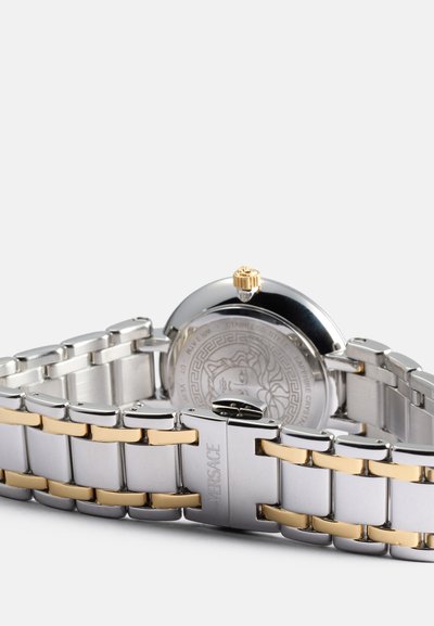 Orologio in acciaio inox con bracciale bicolore argento e oro, cassa rotonda e dettagli sulla corona. Il retro presenta un design di un leone in rilievo.