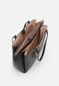 Czarna skórzana torebka z dwoma przegrodami, złotym okuciem, różowym wnętrzem, teksturowanym zewnętrzem oraz łańcuszkowym akcentem na pasku.