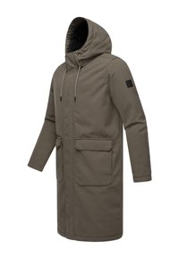 Cappotto lungo verde oliva con cappuccio, chiusura con cordoncino, due tasche frontali e tessuto testurizzato. Presenta una toppa con logo sulla manica.