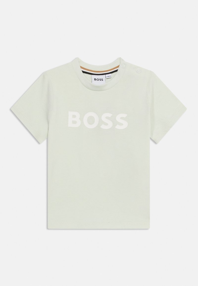 Ανοιχτό πράσινο κοντομάνικο μπλουζάκι για νήπια με λευκή επιγραφή "BOSS" στο εμπρόσθιο μέρος, στρογγυλή λαιμόκοψη και δύο κουμπιά σούστα στον αριστερό ώμο.