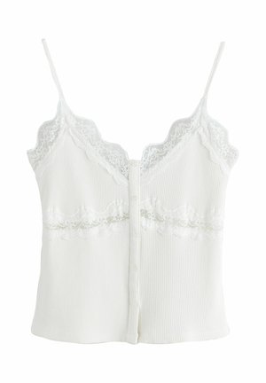 Fehér bordázott trikó csipke díszítéssel a nyakkivágásnál és a mell alatt, vékony pántokkal és elöl gombos záródással.