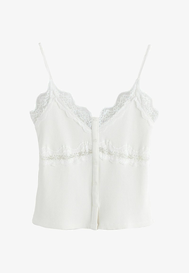 Camisole blanc côtelé avec bordure en dentelle le long de l'encolure et sous la poitrine, dotée de fines bretelles et d'une fermeture à boutons sur le devant.