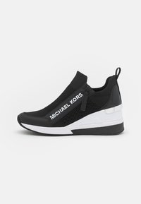Svart atletisk sneakersko med mesh-paneler, glidelåsdetalj og hvit logo. Har en kildekk med en teksturert svart og hvit såle.