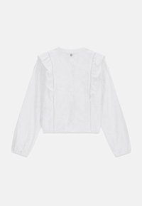 Valkoinen pitkähiha blouse, jossa on kukkakuosiset pitsiyksityiskohdat, röyhelömäinen pystysuora kaulus edessä ja joustavat hihansuut, esillä yksinkertaisella taustalla.