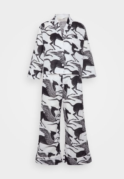 Conjunto de pijama em preto e branco, apresentando uma camisa estampada de mangas longas e calças largas combinando. Feito de tecido leve.