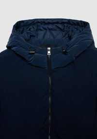 Giacca imbottita blu navy con cappuccio trapuntato, chiusura frontale con zip e dettagli con coulisse. Texture liscia con design elegante e senza loghi visibili.