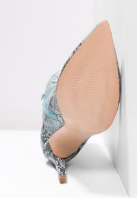 Högklackad sko med spetsig tå, med ett blått och grått ormskinnsmönster, texturerad yta och en smal, mintgrön dragkedjeaccent.