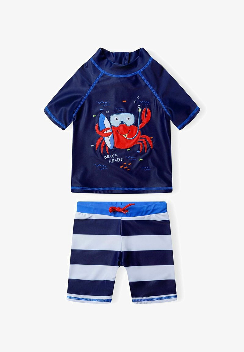 Tengerészkék fürdőruha szett, amely rövid ujjú felsőrészből áll rák mintával és hozzá illő csíkozott rövidnadrággal. Gyorsan száradó, könnyű anyagból készült.