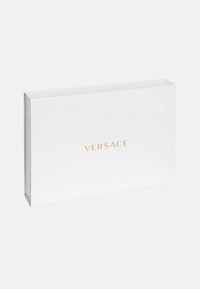 Bijela pravokutna kutija s natpisom "VERSACE" ispisanim zlatnom bojom, glatke teksture, minimalističkog dizajna, bez vidljivih uzoraka ili hardvera.