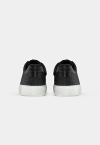 Sneaker neri con tomaia testurizzata caratterizzata da un design con logo ripetuto, punta arrotondata e suola in gomma bianca. Collo imbottito per il massimo comfort.